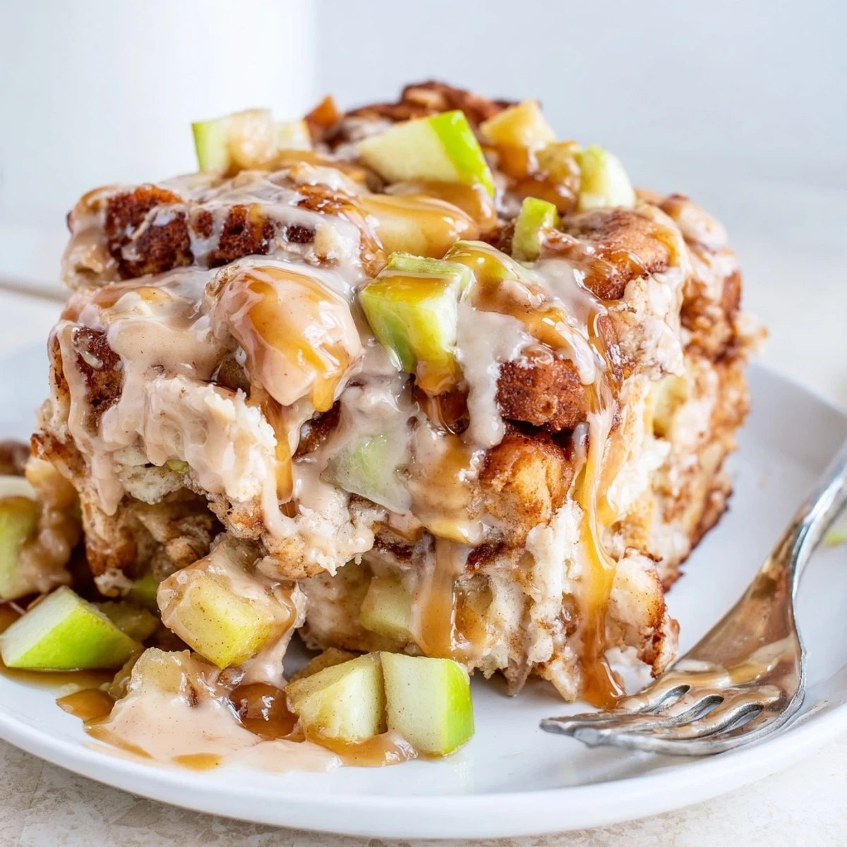 Warm Caramel Apple Cinnamon Roll Bake topped with gooey caramel and cinnamon drizzle.  