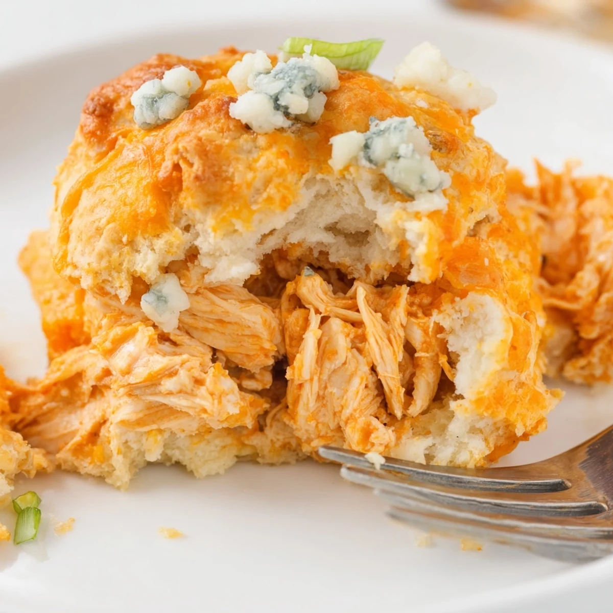 Fluffy buffalo chicken soda biscuits topped with crumbled blue cheese and scallions.  