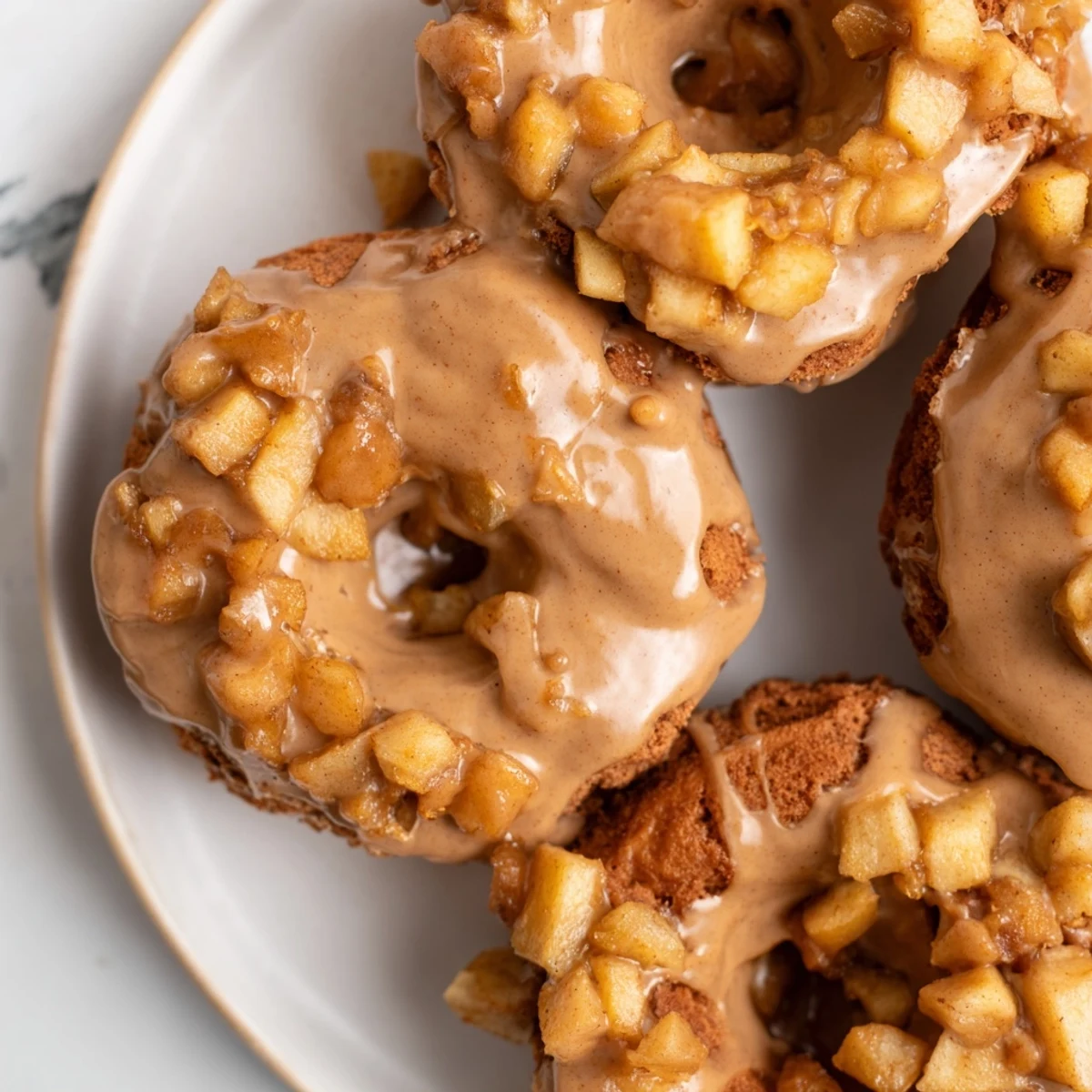 Fluffy Chai Caramel Apple Pancake Donuts drizzled with rich caramel glaze and spices.  