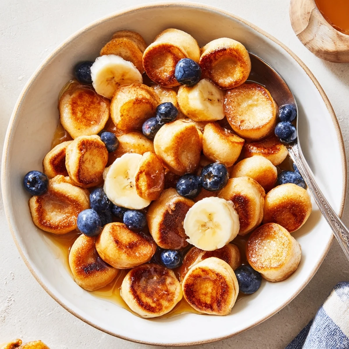Delicious mini pancake cereal, fluffy bites topped with fresh berries and syrup.  