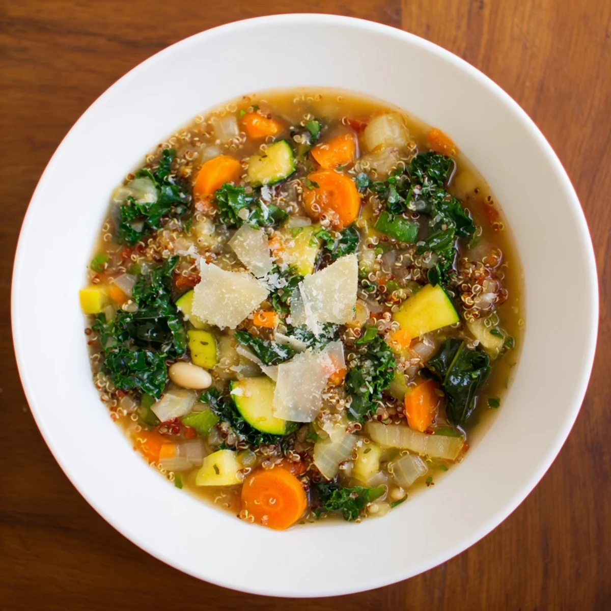 Steaming bowl of Minestrone with Quinoa & Winter Greens garnished with fresh parsley, ready to enjoy.