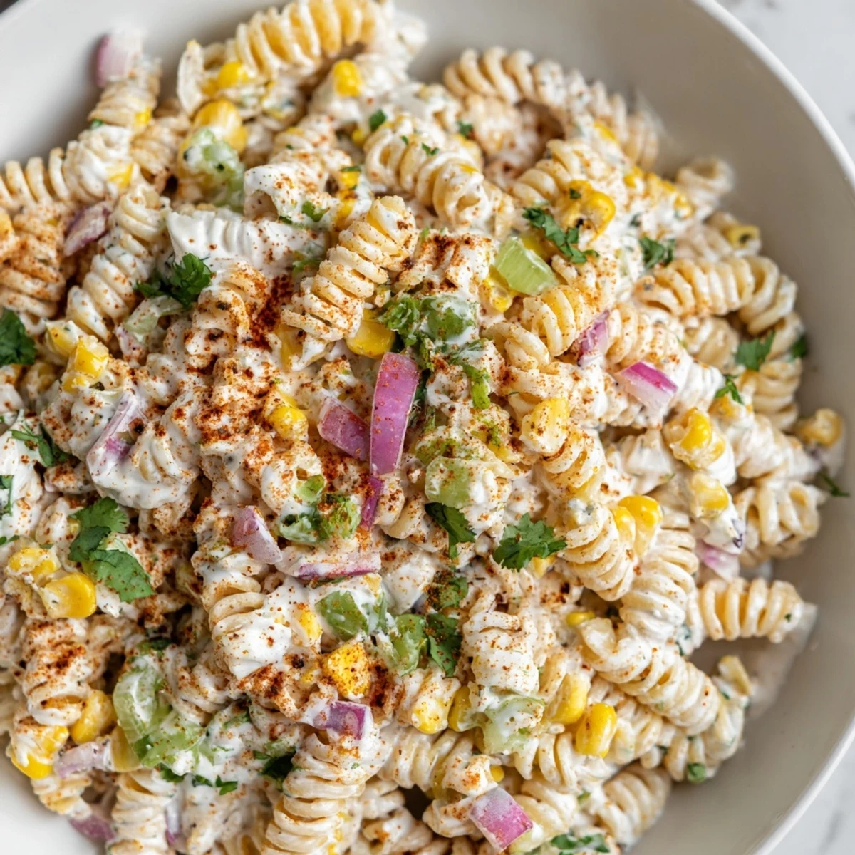 Vibrant bowl of Mexican Street Corn Pasta showcasing the fresh cilantro and crumbled cotija cheese.