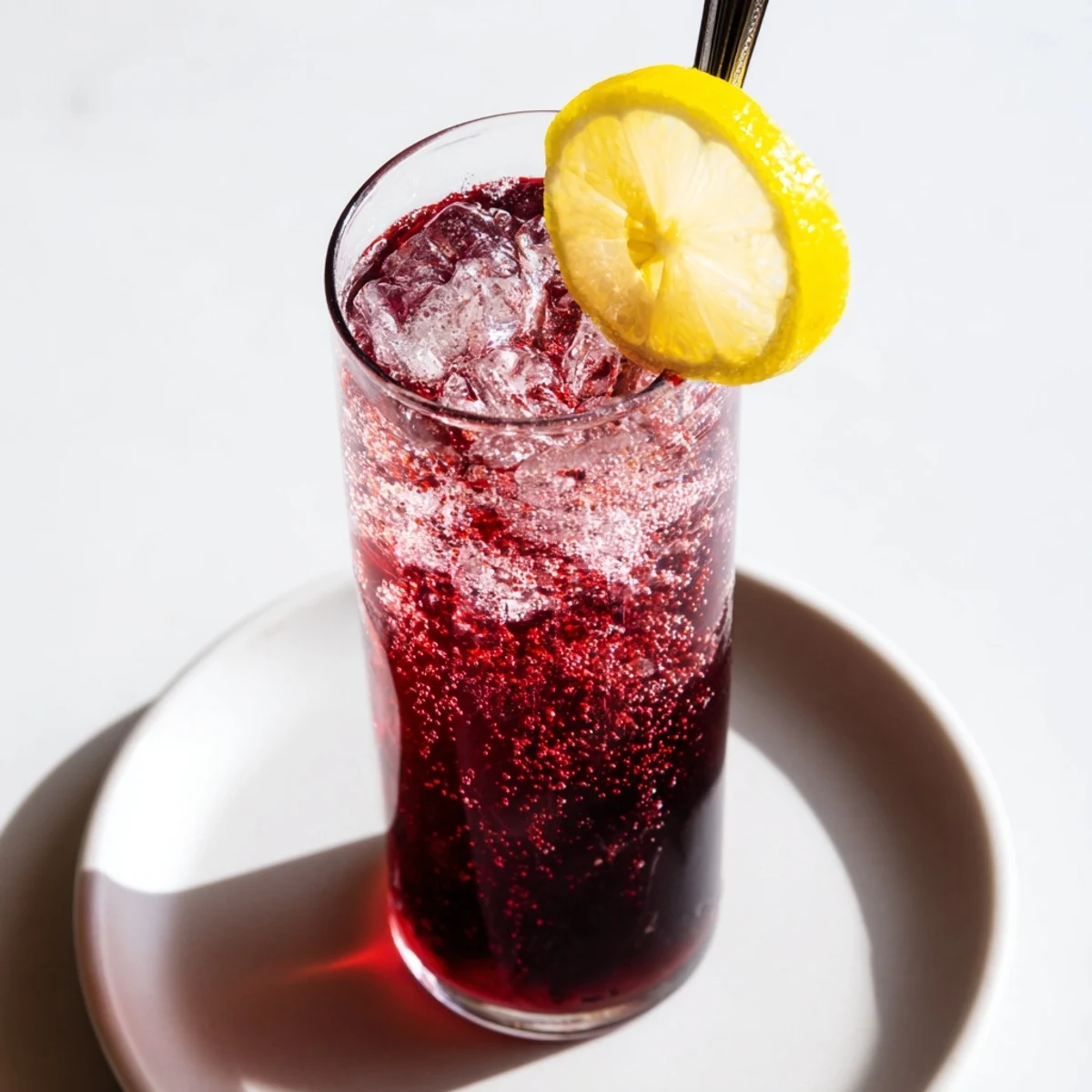 Refreshing Sleepy Girl Mocktail with a deep red hue, garnished with a bright lemon wheel for a treat.
