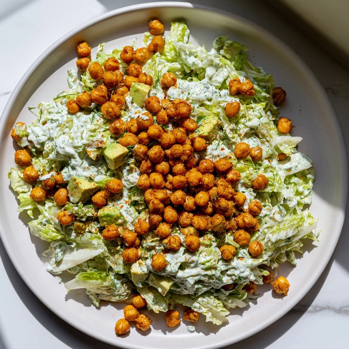 Close-up of a refreshing Green Goddess Salad showcasing vibrant greens layered with crunchy chickpeas.