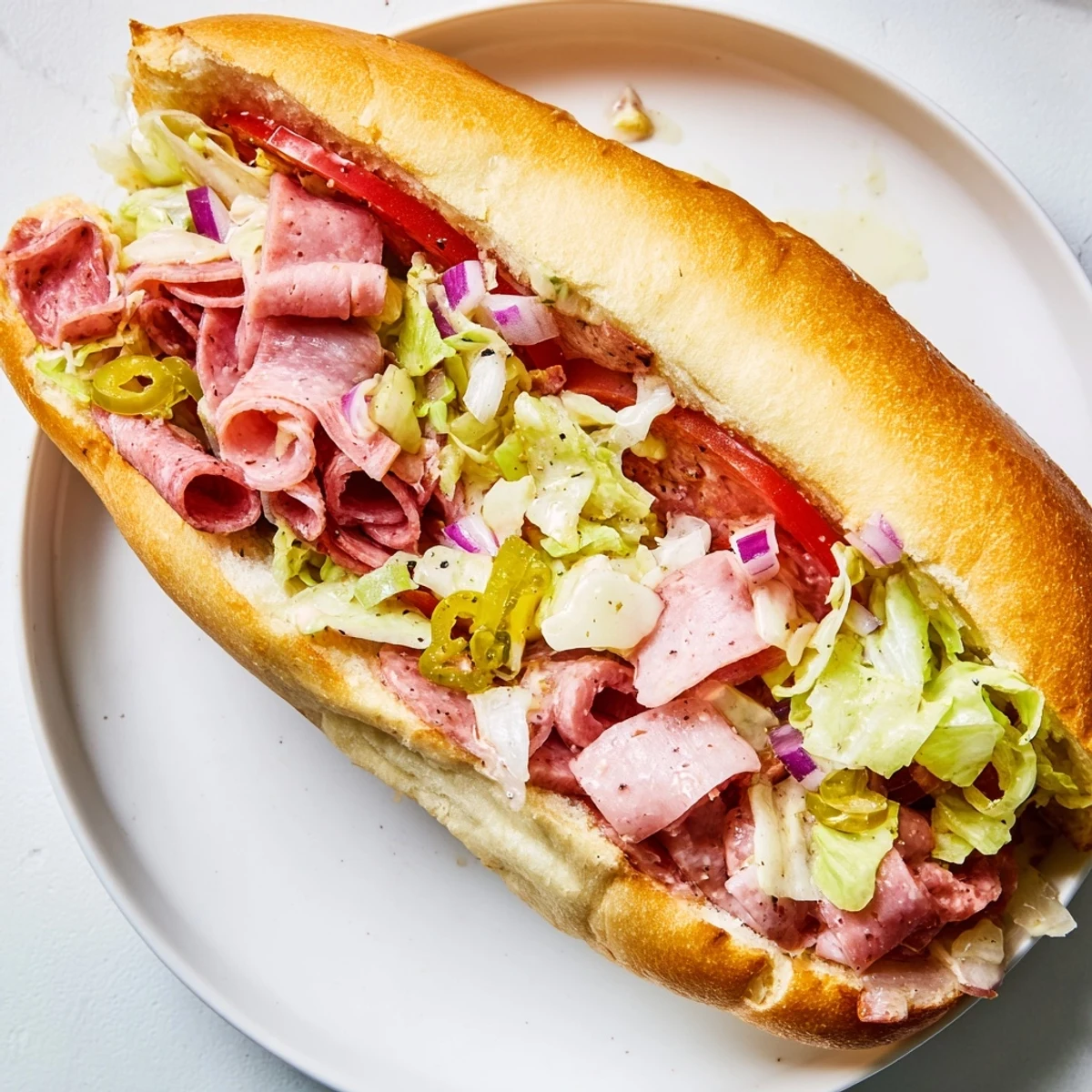 Chopped Italian Grinder sandwich overflowing with meats and cheese, ready to eat on a toasted hoagie.