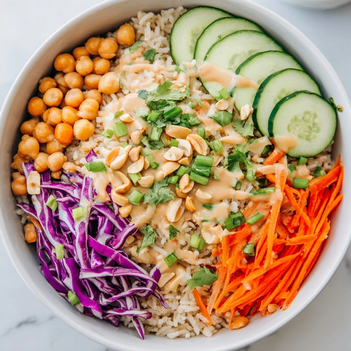 Ready in under 45 minutes, a hearty Peanut Chickpea Rice Bowl is topped with fresh cilantro, scallions, and a drizzle of savory peanut dressing.