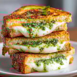 Golden-brown Grilled Cheese with Pesto and Mozzarella on rustic bread, served hot and melty for lunch.