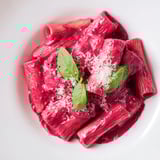 This Pink Pasta with Beet Cream shows cooked pasta enveloped in a smooth, pink beet sauce and Parmesan.