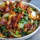 Golden-brown fried cabbage, bacon, and onion side dish ready to serve.