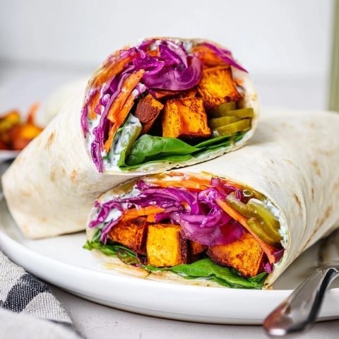 Close-up Sweet Potato & Pickle Chip Wrap: toasted tortilla filled with colorful ingredients.