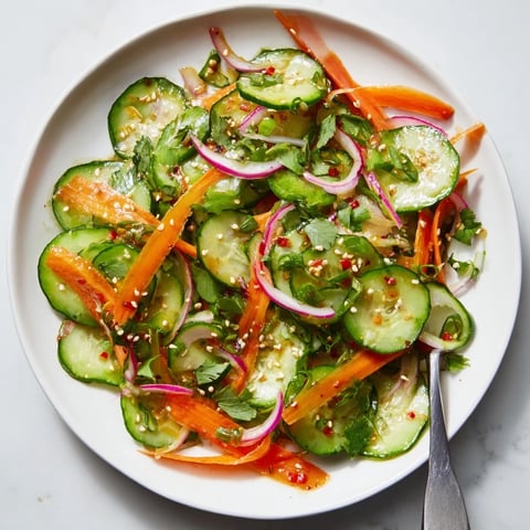 Refreshing cucumber salad remix with vibrant vegetables and savory Asian dressing.  