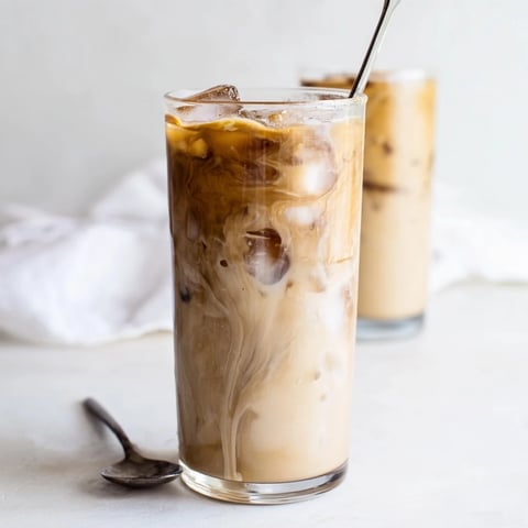 Smooth and creamy Tahini Iced Coffee topped with plant-based milk and ice.  