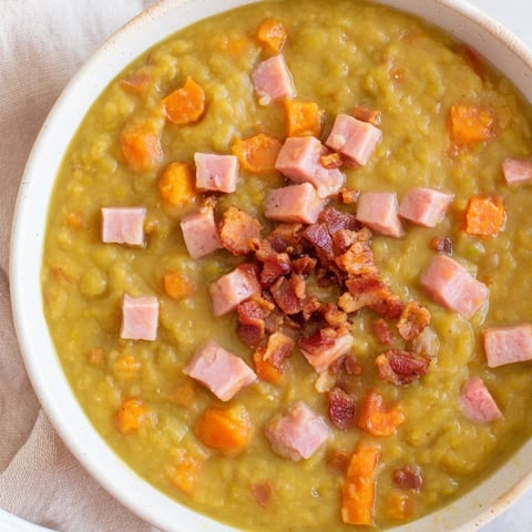 Steaming bowl of Split Pea Soup with canned ham and bacon, garnished with crispy bacon crumbles.