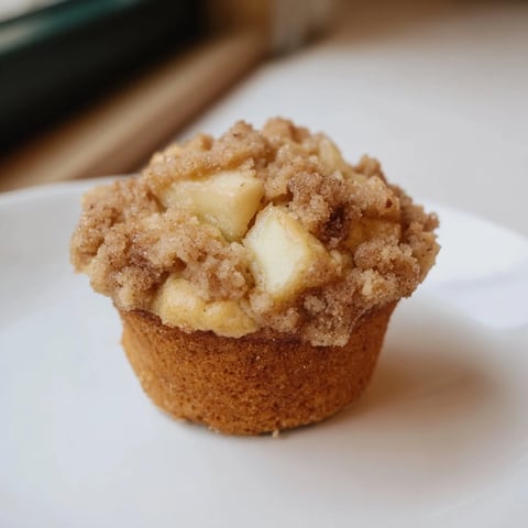 Warm, golden Tasty Apple Muffins, with a perfectly textured crumb topping, ready to enjoy for breakfast.