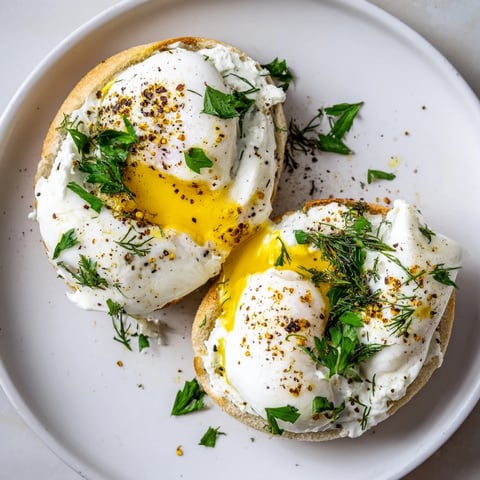 Çılbır Eggs Benedict: Vibrant poached eggs sit atop creamy garlic yogurt, drizzled with spiced butter.