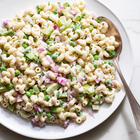 Creamy Dill Pickle Pasta Salad featuring ditalini pasta, crunchy diced pickles, and sweet green peas in a zesty dressing.  