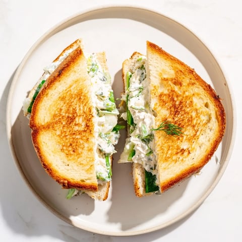 Toasted golden sourdough slices stuffed with creamy whipped feta spring grilled cheese, topped with fresh dill and lemon zest.