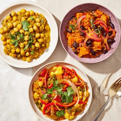 Colorful Thai red lentil curry in a bowl, topped with basil and lime zest.  