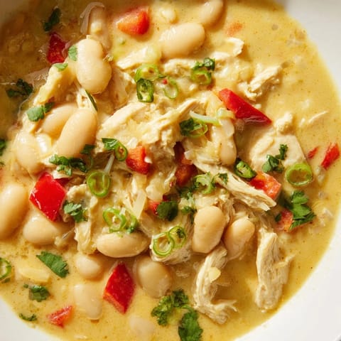 A steaming bowl of creamy white chicken chili with beans, perfect comfort food, ready to enjoy.