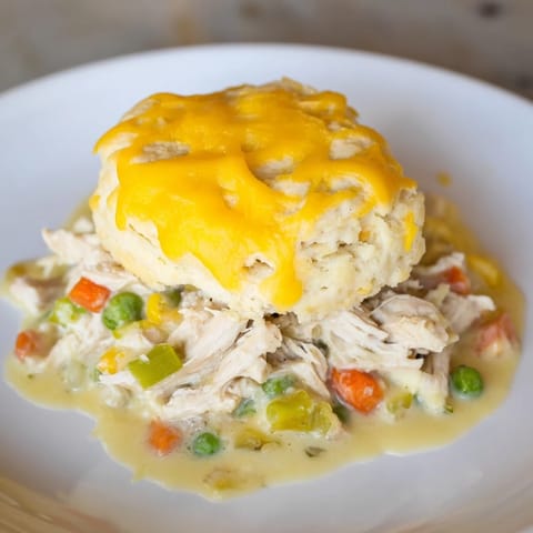 A bubbling One-Pan Chicken Cobbler, with savory chicken filling and fluffy cheddar biscuits on top.