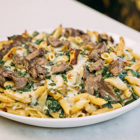 This delicious Steak & Spinach Artichoke Pasta Bake features tender steak and flavorful artichokes in a rich, cheesy sauce.