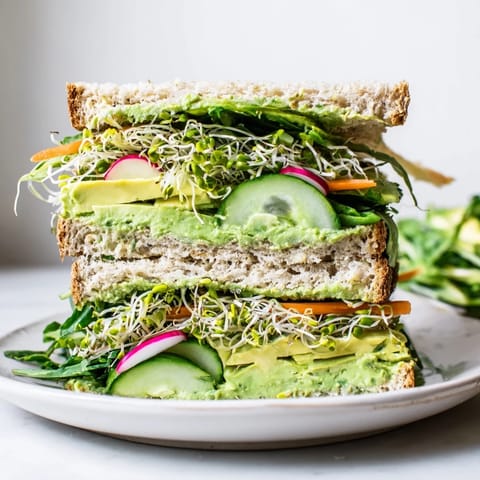Freshly assembled Green Goddess sandwich showcasing creamy spread and crunchy, healthy ingredients.