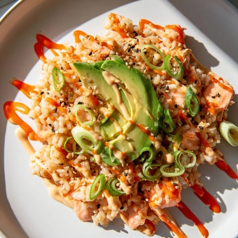 Warm Emily Mariko Salmon Rice Bowl with creamy avocado and spicy mayo, perfect for lunch.