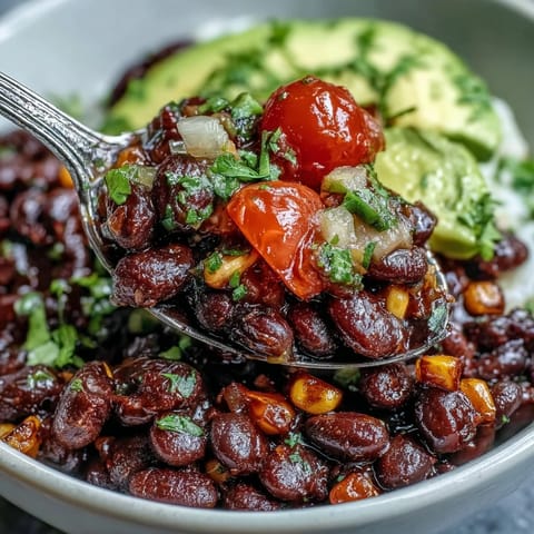 Hearty vegan taco bowl, generously topped with avocado, corn, and juicy tomatoes.