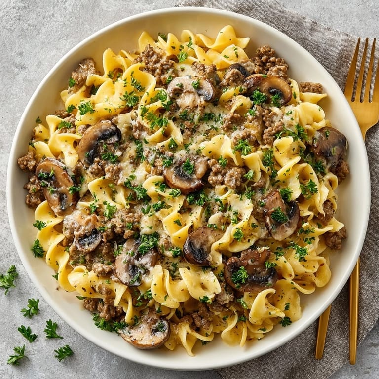 Hot taco seasoned ground beef stroganoff, garnished with cilantro, filling a large serving bowl.