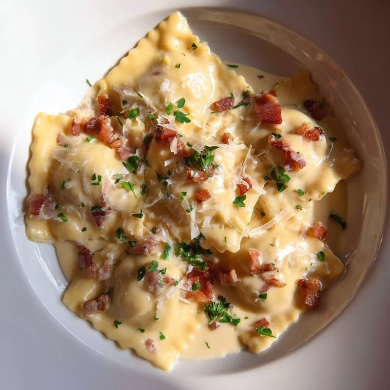 Golden-brown pancetta tops a bowl of Olive Garden Ravioli Carbonara, a comforting pasta dish with fresh parsley.
