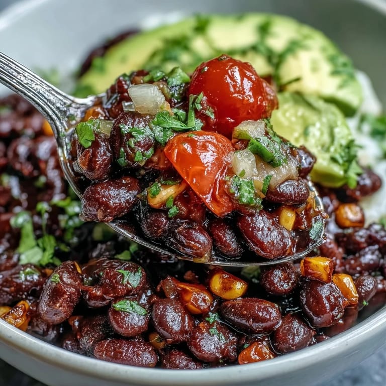 Hearty vegan taco bowl, generously topped with avocado, corn, and juicy tomatoes.