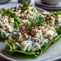 Creamy avocado and egg salad nestled in crisp lettuce leaves, topped with crunchy everything bagel seasoning for a fresh keto lunch.  