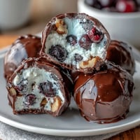 Wholesome frozen blueberry yogurt clusters with crunchy walnuts and dark chocolate coating, perfect for healthy snacking.  