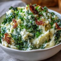 Creamy mashed potatoes with sautéed leeks and crispy kale, offering a modern twist on traditional Irish colcannon comfort food.