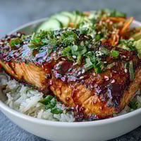 Quick teriyaki salmon bowl with glazed salmon, avocado, cucumber, and sesame seeds over jasmine rice.