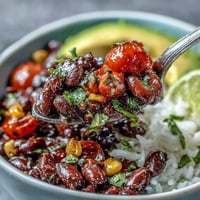 Colorful plant-based taco bowl piled high with seasoned black beans and fresh salsa.